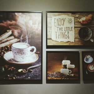 Gallery wall with coffee-themed art including cups and an inspiring message.