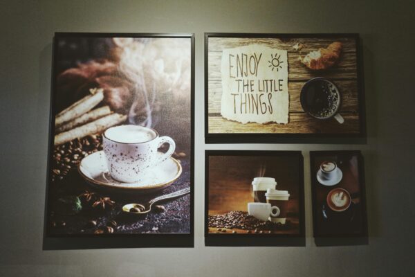 Gallery wall with coffee-themed art including cups and an inspiring message.