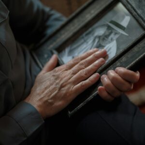 A close-up shot of hands gently holding a vintage framed photograph, evoking nostalgia and memories.