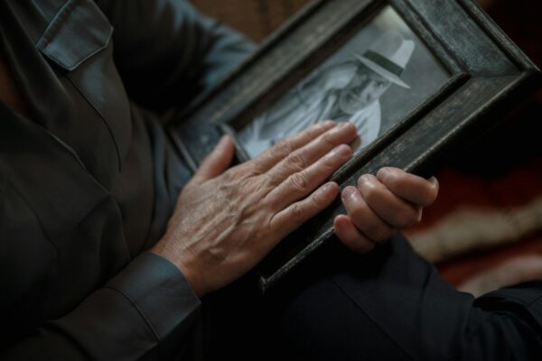 A close-up shot of hands gently holding a vintage framed photograph, evoking nostalgia and memories.